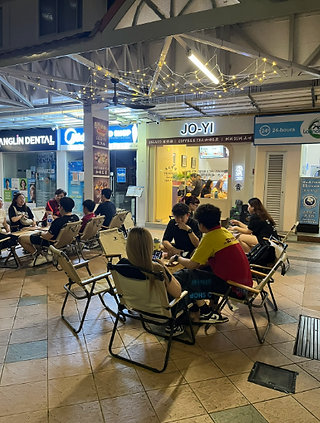 Outdoor seating under string lights at JO-YI CAFE in Bedok North at night