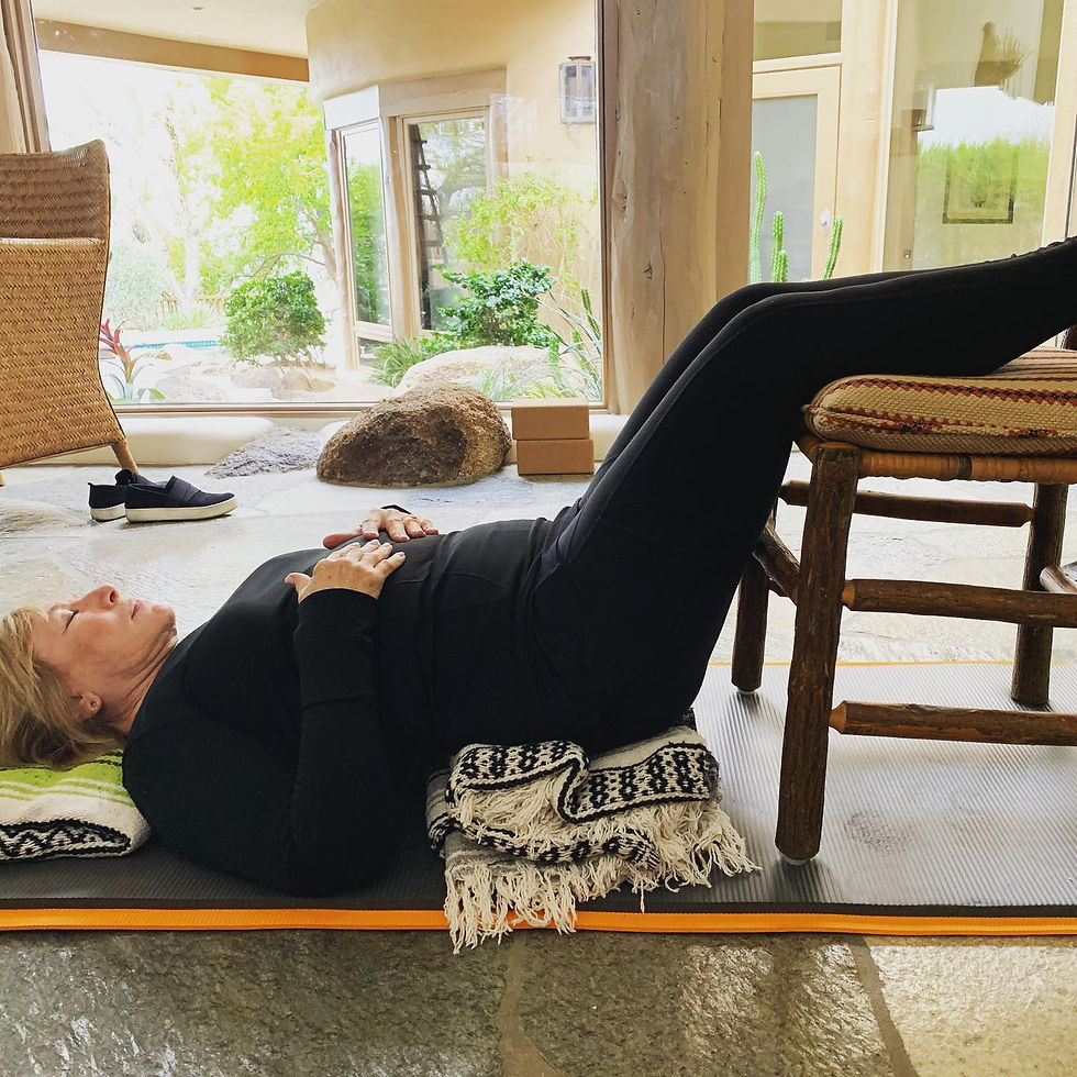 Supine restorative posture supported with a chair and yoga blankets