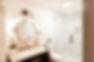 Vintage inspired bathroom design with round gold mirror, marble vanity, and glass shower.