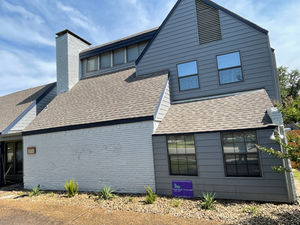 Landscaped side yard with mulch bed beside a gray house – Good Deal Builder, Dallas TX