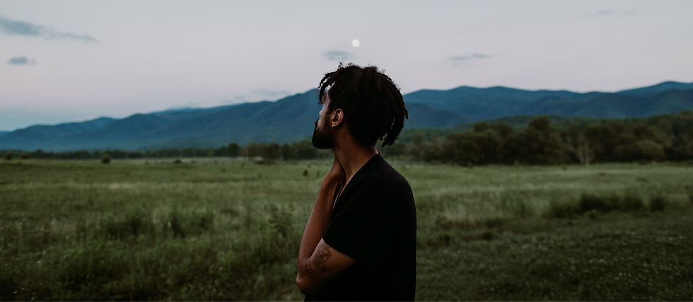 Black man in nature outdoors gazing the surrounding