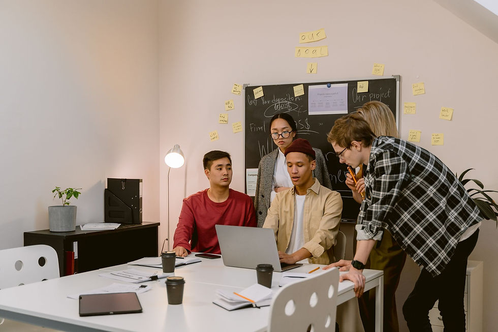 Colleagues discussing ideas together around a laptop in an office