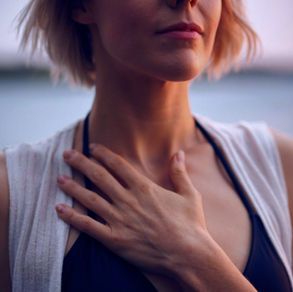 Junge Frau, die ihre linke Hand aufs Herz legt.