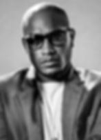 Stylized image of Christofer Tracy wearing sunglasses and a textured blazer