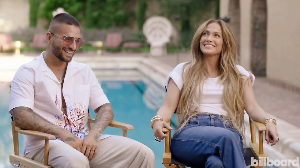Jennifer Lopez and Maluma seated poolside during a glamorous interview for the Latin Billboard Awards.