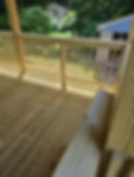Custom-built wood porch railing with vertical balusters and smooth handrail