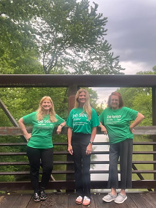 Allen County Guardianship Services Board members wearing green Be Seen shirts on a bridge during Mental Health Awareness Month.