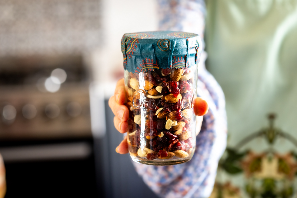 Glass jar filled with nuts and raisins with beeswax wrap to close it