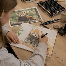 Ung jente tegner rød panda på onsdag tegning, maling og sketching.