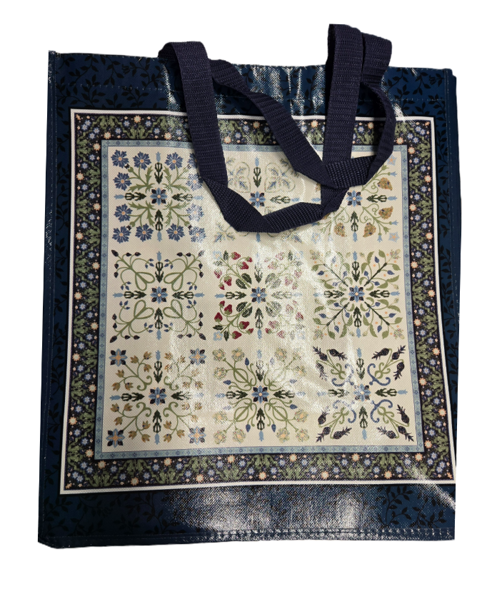 Dark blue vinyl coated shopping tote with quilt designs on cream