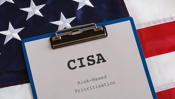A blue clipboard on an American flag. the paper on the clipboard reads “CISA Risk-Based Prioritization"
