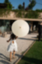 Flower girl with a white parasol walking at a luxury outdoor wedding in Italy, photographed by Nando Spiezia — natural, elegant and storytelling wedding photography on the Amalfi Coast.