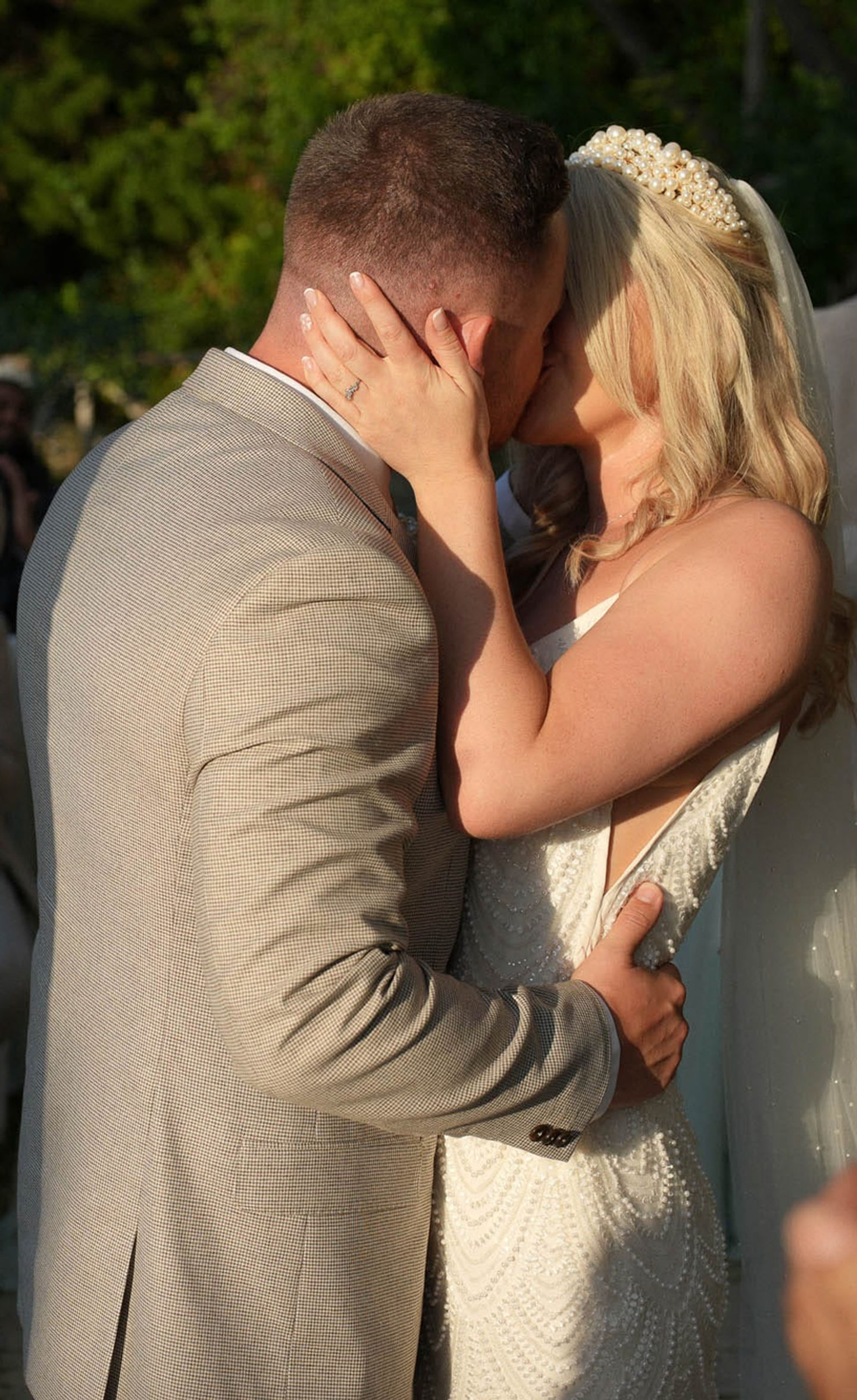 Couple dancing closely surrounded by friends, laughter and happiness filling the evening air.