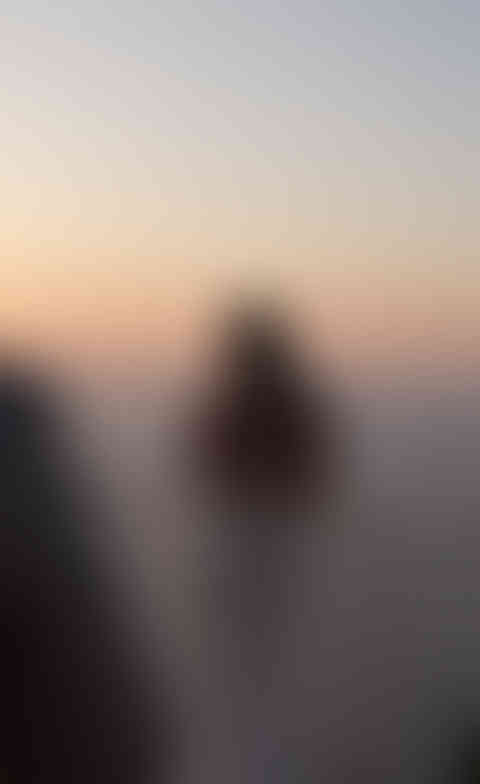 Groom embracing the bride on the terrace at sunset, romantic silhouette moment overlooking the Italian coast.