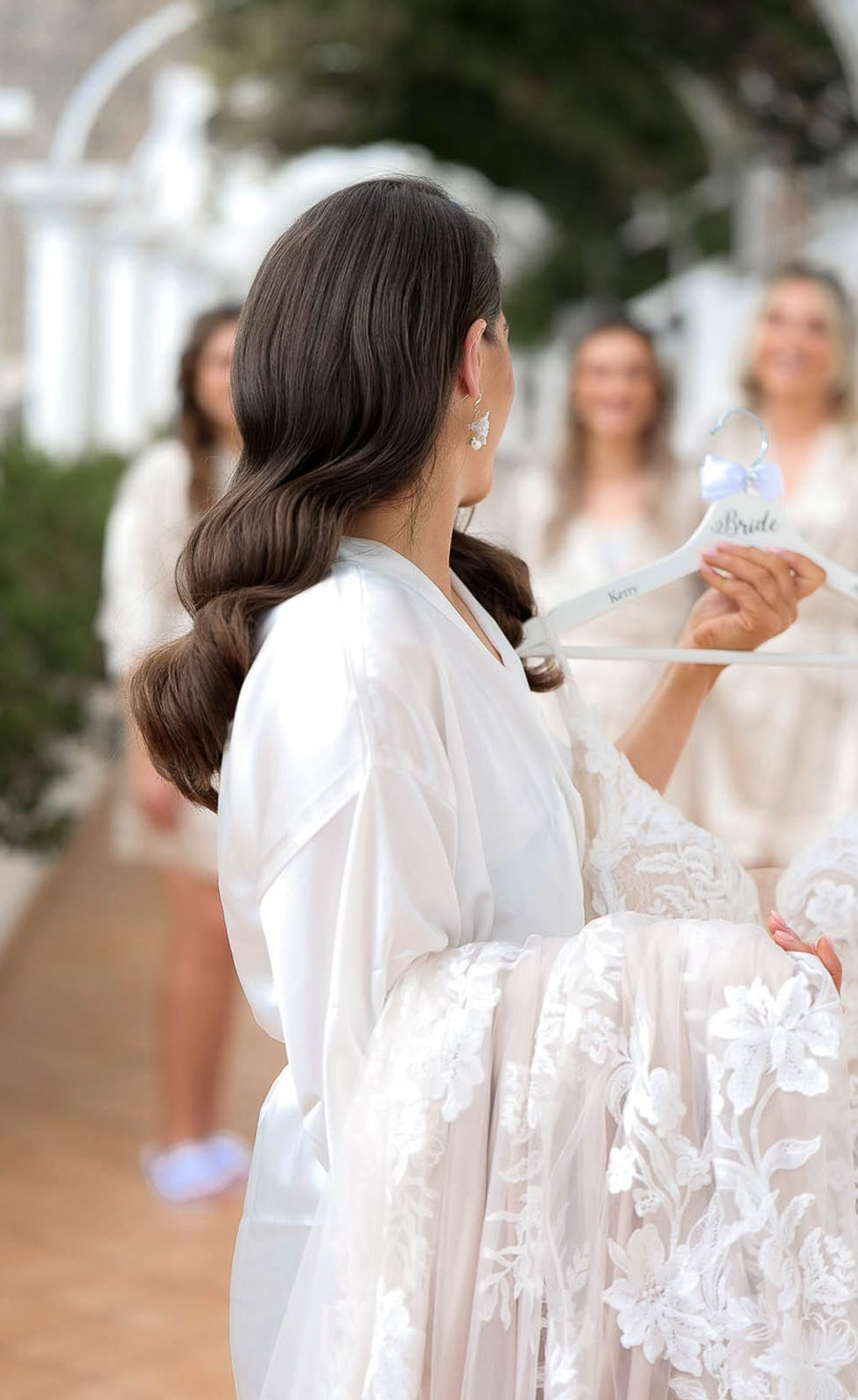 Bride seen from behind walking through the villa hallway, soft veil movement adding elegance.