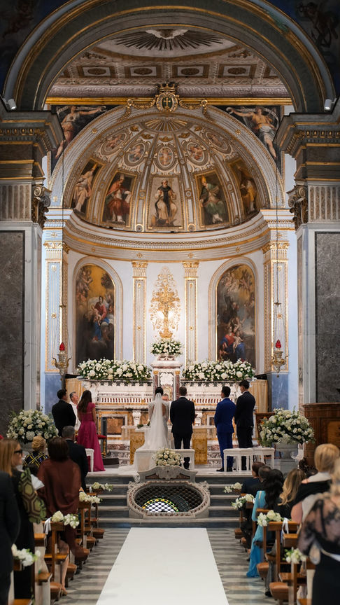 Couple exchanging vows inside the elegant church, golden light illuminating the ceremony.