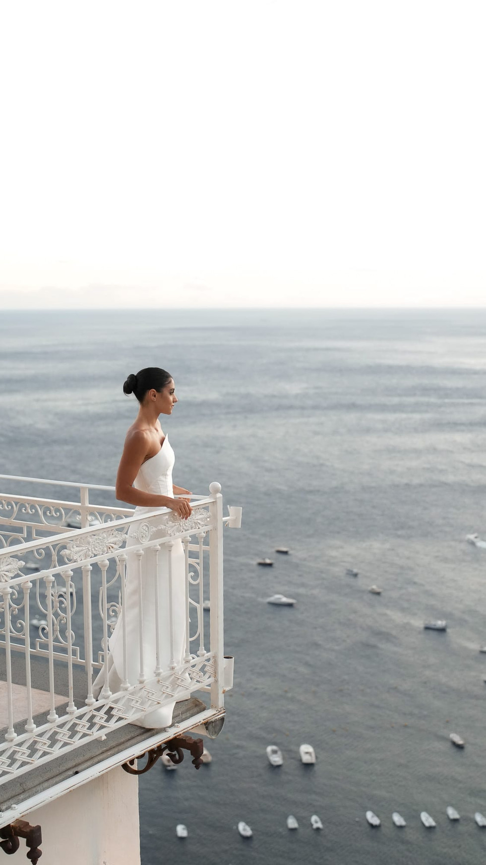 Bride in white dress looks out over ocean; destination wedding positano. Nando Spiezia Photography