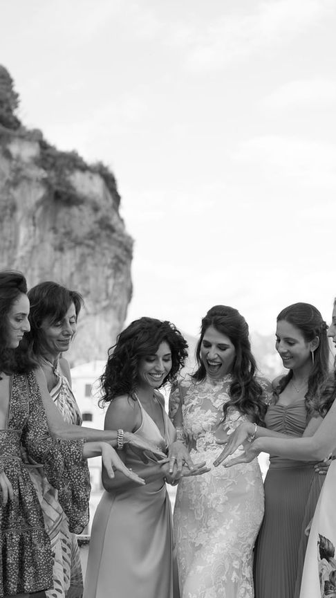 Bride and bridesmaids walking through the garden path, cheerful morning moment filled with anticipation.