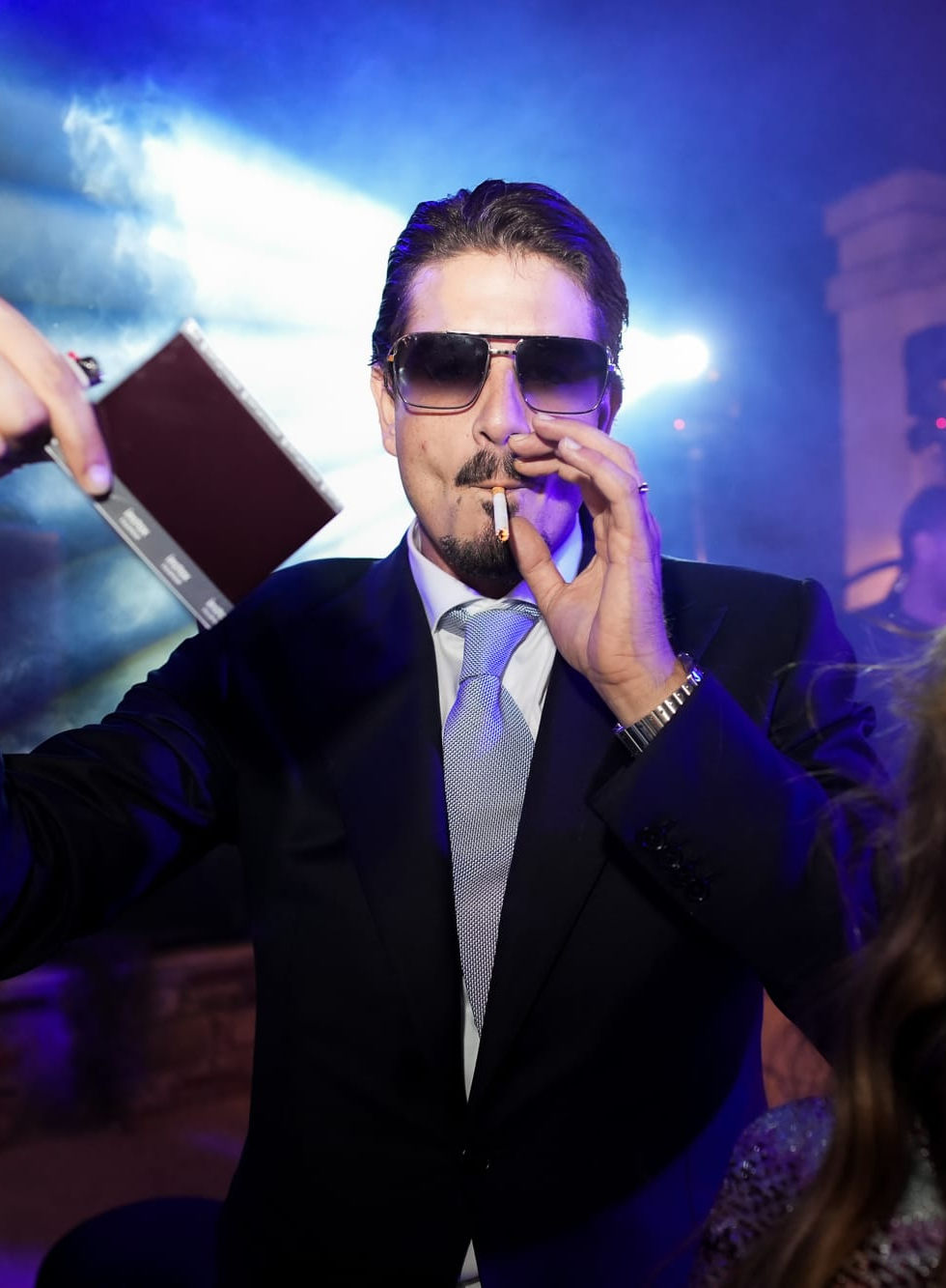 Groom in sunglasses performing during the party, energetic and fun twist to an elegant evening celebration.