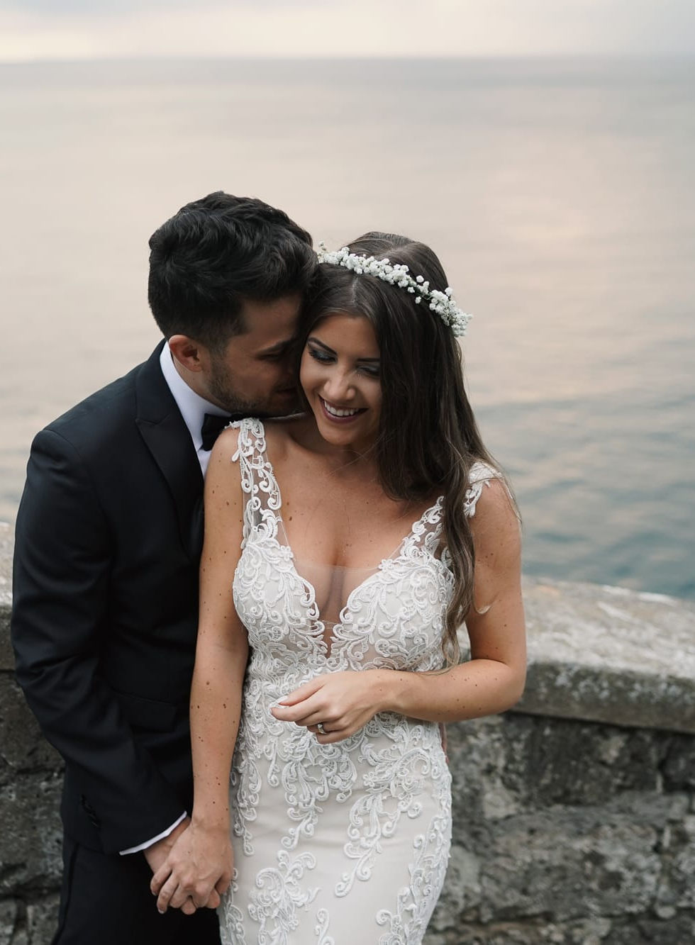 Couple sharing a romantic moment overlooking the Amalfi Coast, classic Italian wedding portrait.