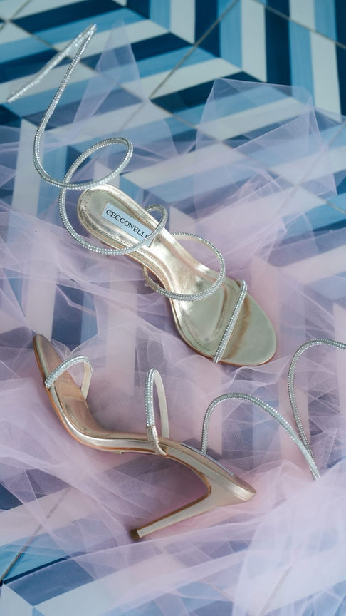 Gli accessori della sposa (profumo, orecchini e velo) sono disposti elegantemente su una superficie decorata: raffinati dettagli per le nozze a Sorrento.