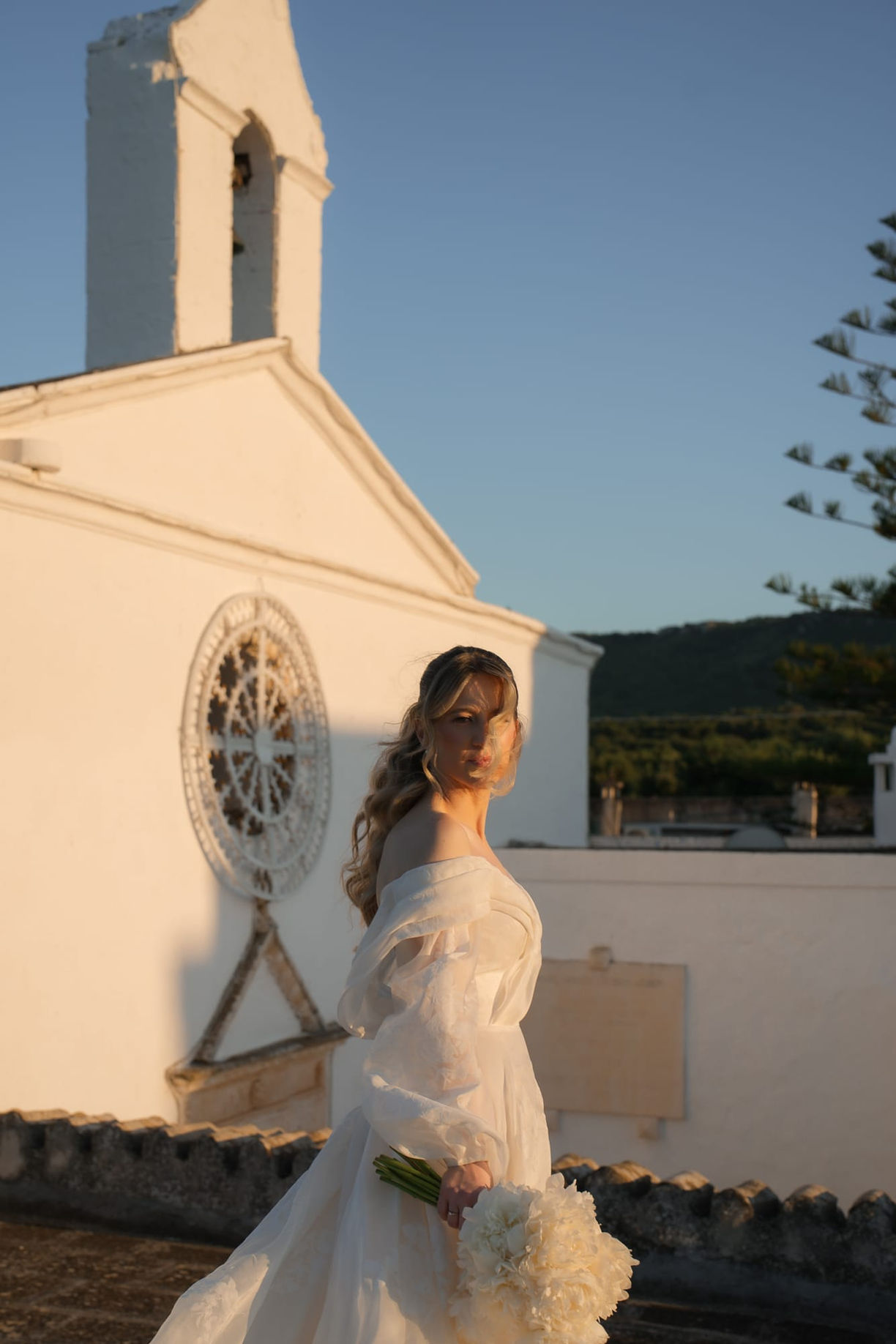 Bride walking along sunlit streets, candid Italian wedding photography.