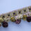 Thumbnail: Vintage woven trim with plush pom-poms in earthy green, beige, and brown tones
