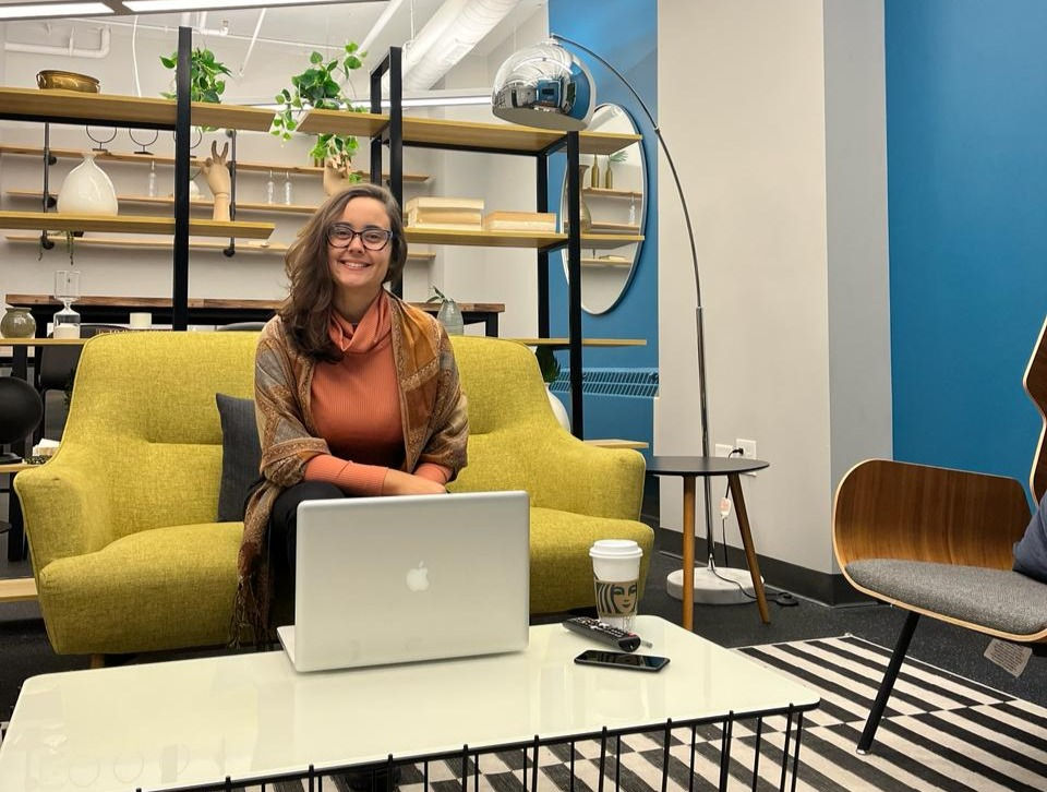 uma mulher sentada no sofa com um notebook