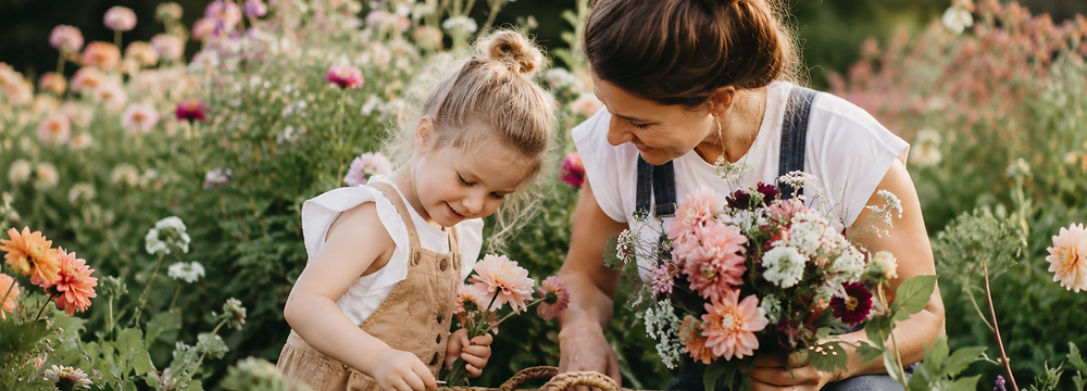 Mama en dochter plukken samen bloemen in een kleurrijke bloementuin tijdens een creatieve ouder-kind workshop bij Atelier Bloemgeluk in Denderleeuw