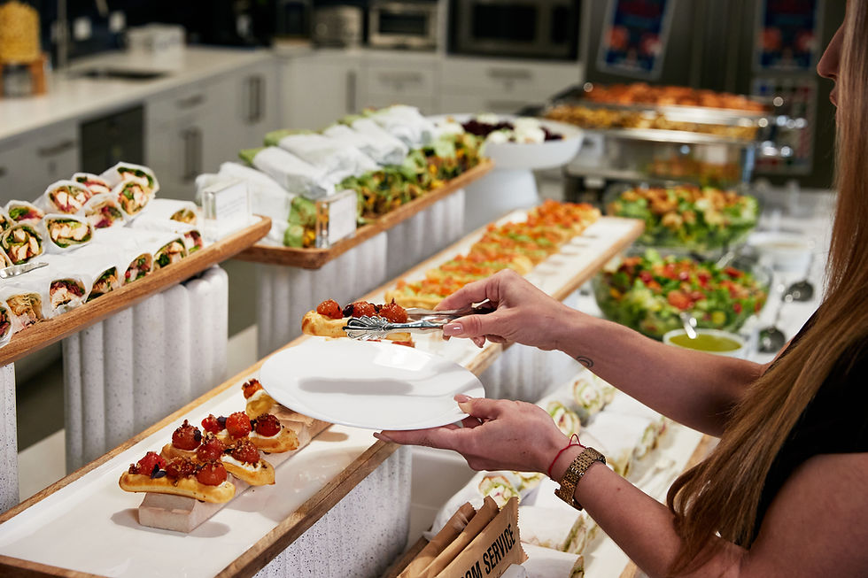 Person serving wraps and appetizers at a WeWork buffet.