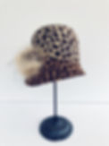 leopard print cloche hat with furry pom pom at the side 