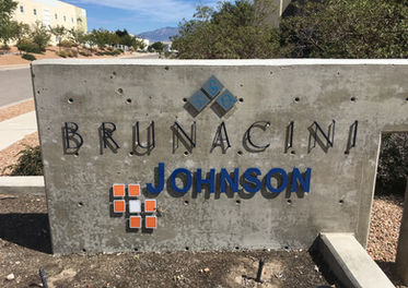 A concrete structure with the word Brunacini Johnson cut out of metal, and standing off from the backing.