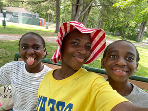A selfie taken outdoors of three people smiling. 
