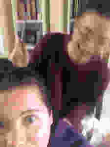 Two girls about to give each other haircuts, one blurry and holding a comb.