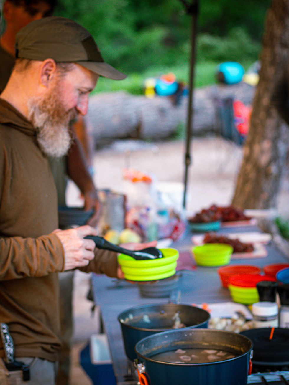 Scott Moss (marine veteran and team leader) takes a helping of stew while on the Smith RIver.