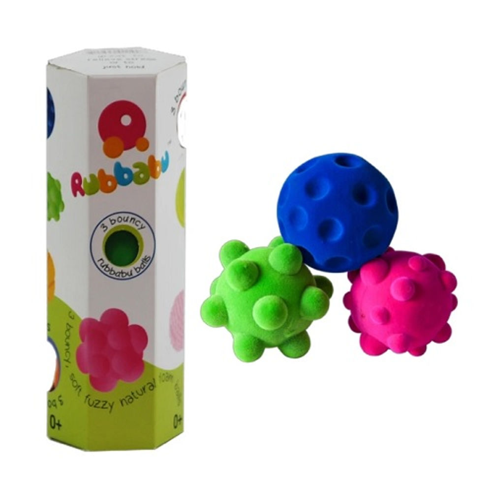 Tres pelotas mini de textura suave y con relieves, en azul, verde y fucsia, junto a su envase hexagonal blanco de la marca Rubbabu que dice 3 bouncy balls. (foto 1 de 2)