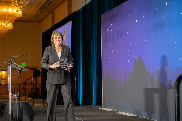 Photo of 2025 Margaret Sevy Lifetime Achievement Award, Pam Blanton, Partners4Housing walking of the stage