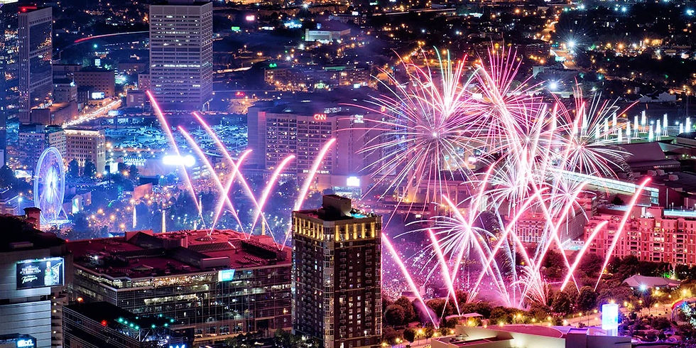 Fireworks light up the downtown Atlanta skyline above Centennial Olympic Park, with SkyView Atlanta's Ferris wheel and the CNN Center visible at night