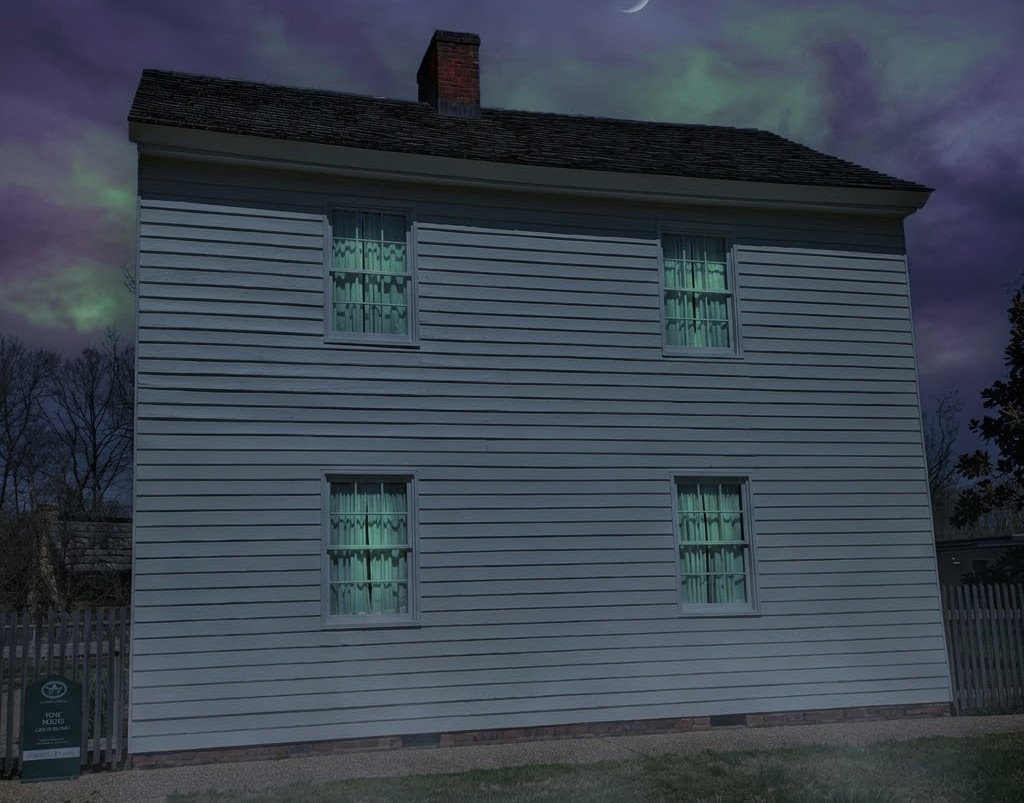 A stark, two-story historic house at night under a crescent moon, featuring an unnatural, glowing green light emanating from its front windows against a dramatic sky.