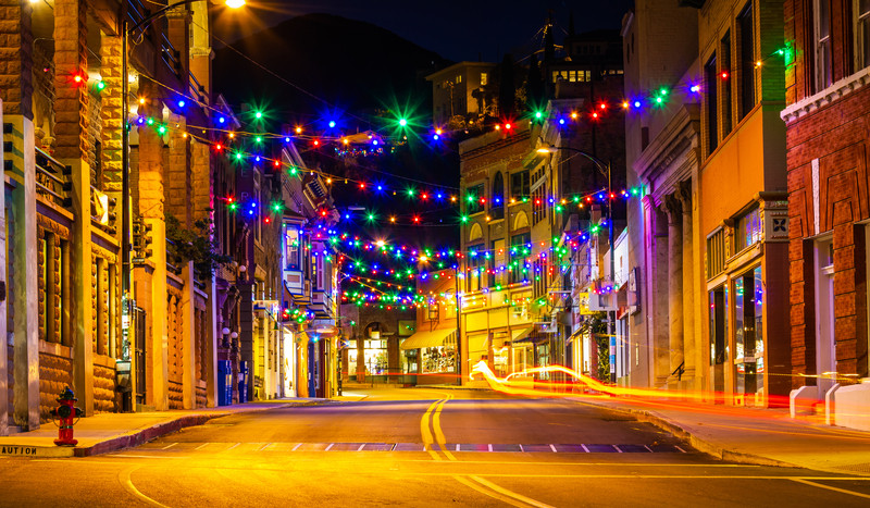 Historic downtown Bisbee street lit by colorful overhead string lights and warm glowing lanterns at night.