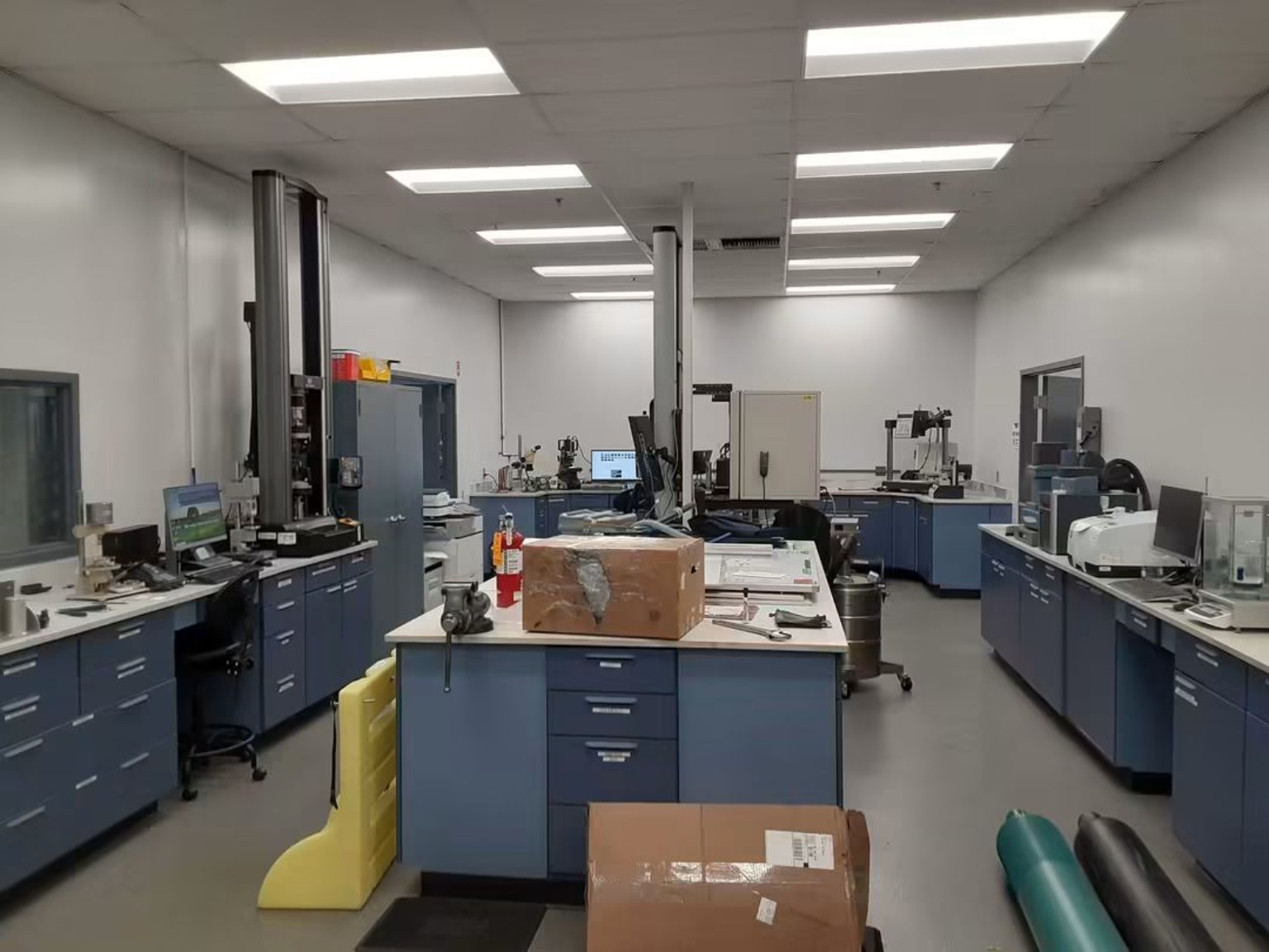 Wide view of a commercial laboratory with specialized instruments, cabinets and freshly painted interior walls