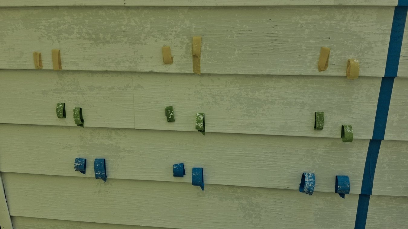 Colored tape markers on an aluminum siding primer adhesion comparison test