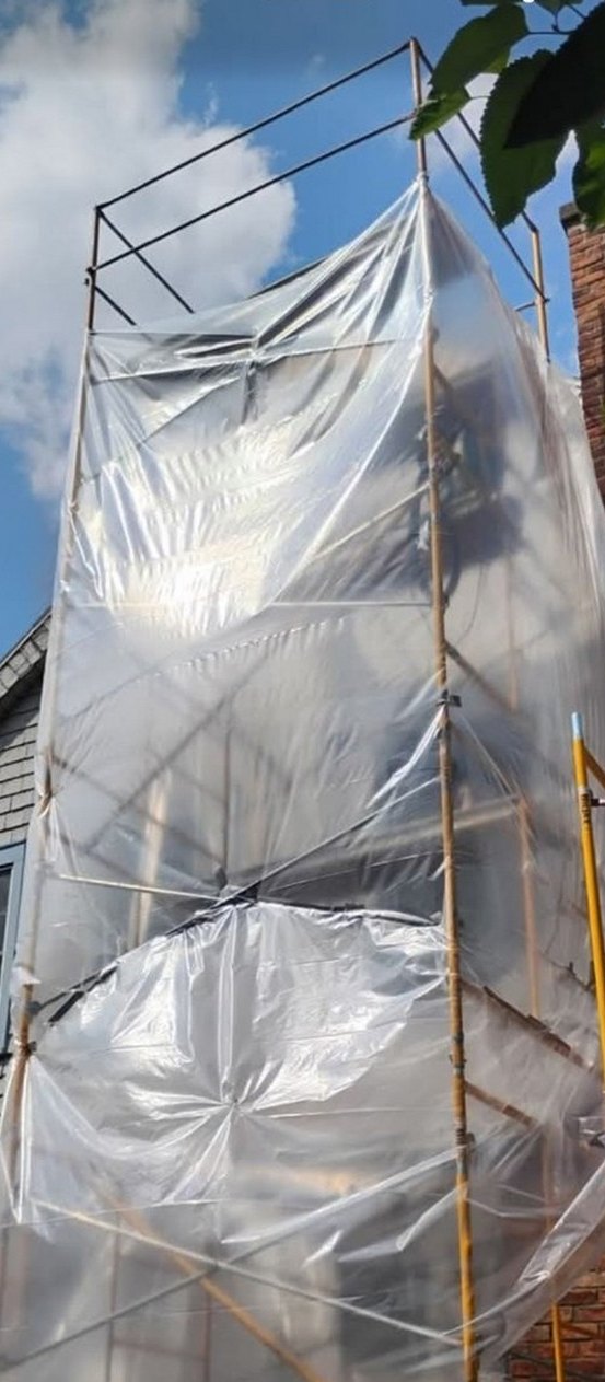 Temporary scaffold access and protective containment sheeting on an anonymized exterior renovation