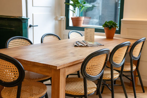 Grote houten tafel met stoelen in een lunchroom in Hoorn – Grosser Café-Tisch.