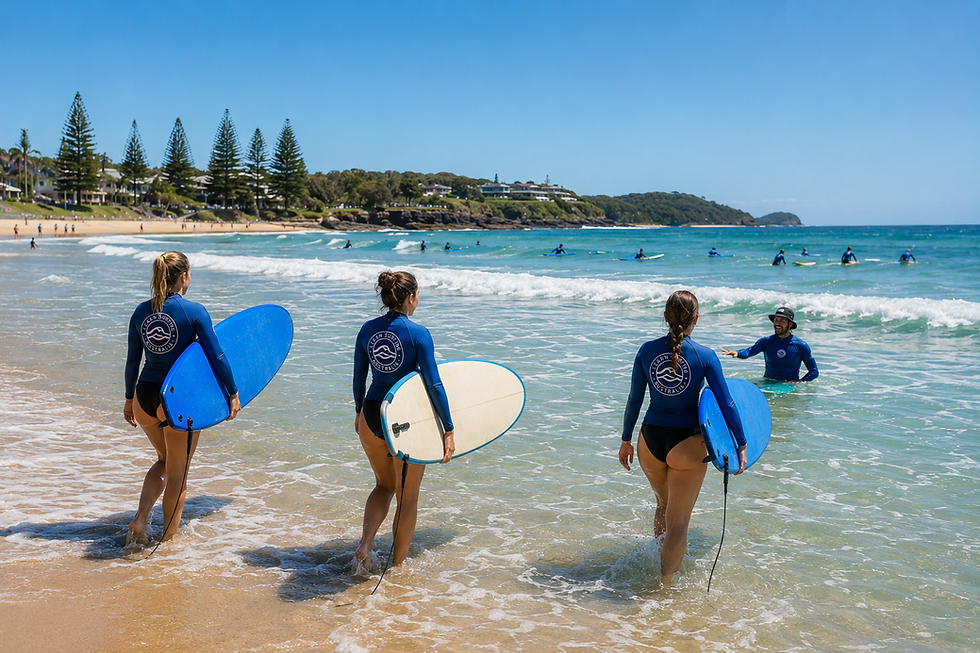 3 beginner surfers entering the water with their boards for a surf lesson at a safe, accredited surf school in one of the best places to learn surfing in Australia.