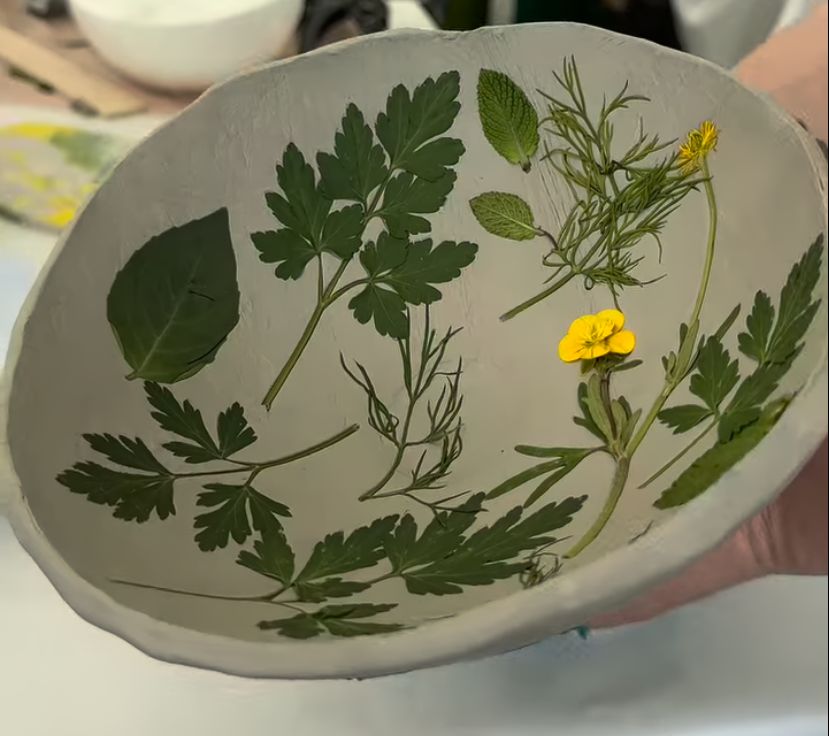 Impression platter with herbs and flowers pressed into clay
