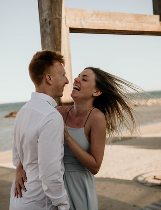 Un couple sur la plage en train de rire