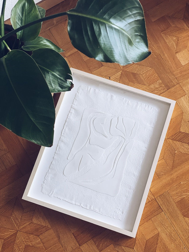 white paper cut on a grain paper leaf with its white frame