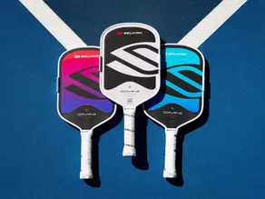 3 Selkirk OMNI pickleball paddles laid out on a pickleball court