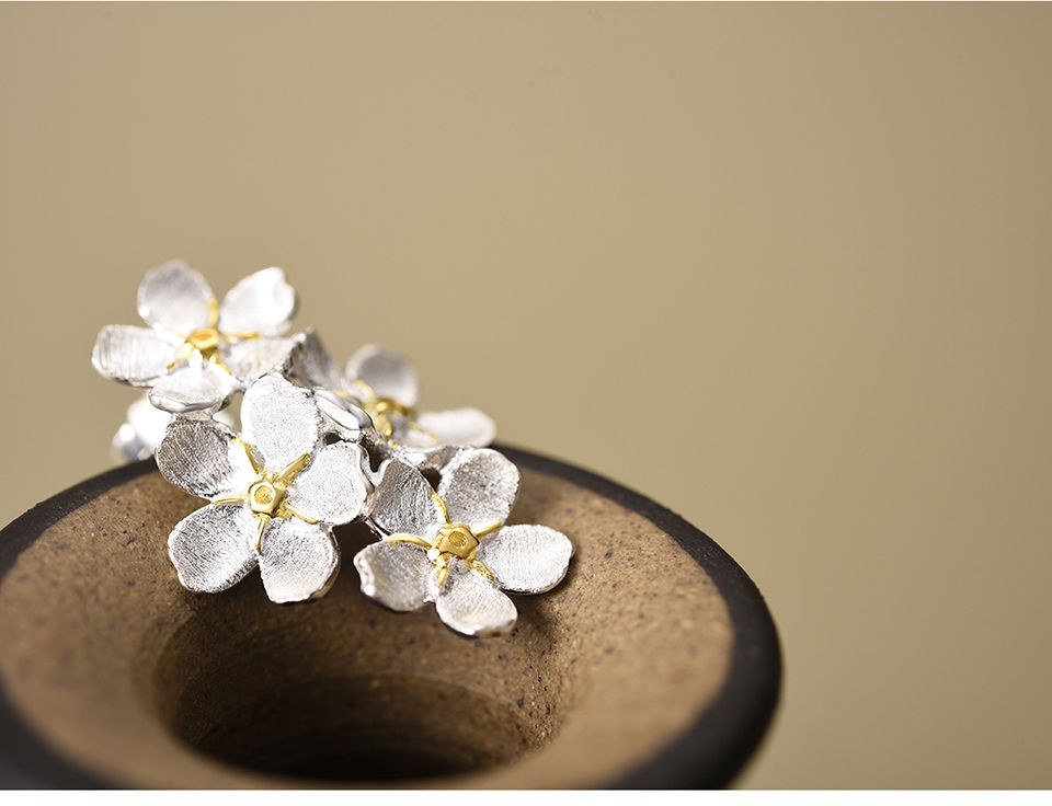 Thumbnail: Silver daisy cluster stud earrings on top of vase